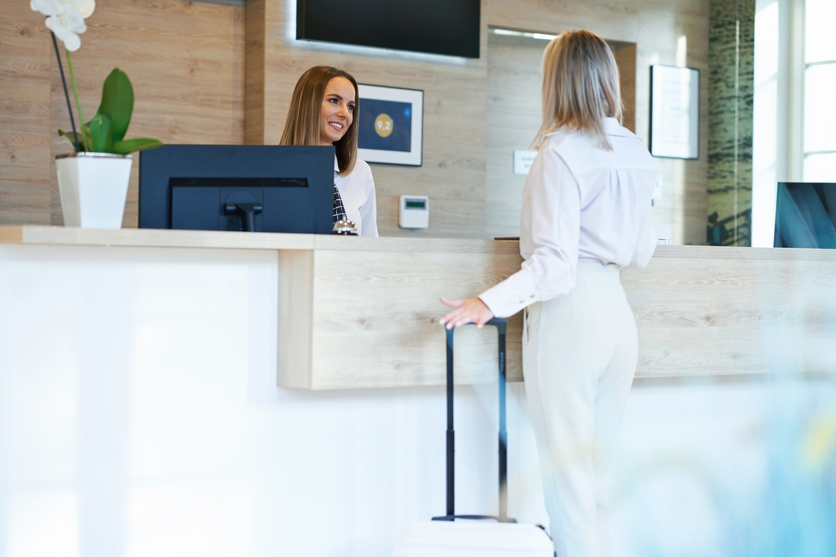 Picture of receptionist and businesswoman at hotel front desk